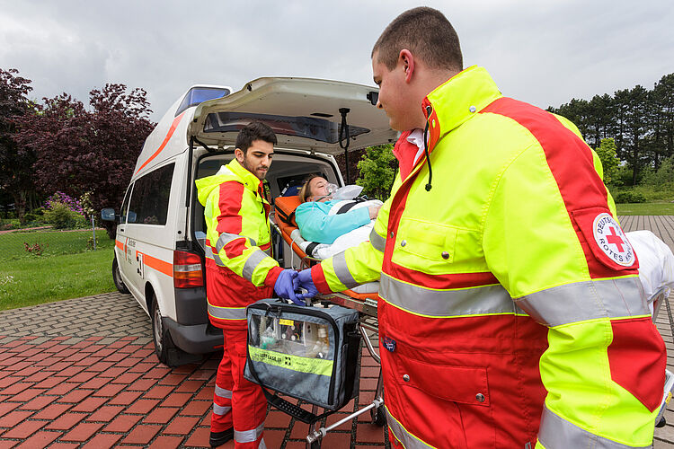 Zwei Helfer arbeiten Hand in Hand beim Krankentransport